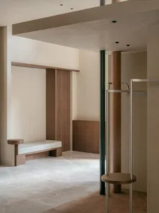 Modern minimalist retail space featuring marble floors and wooden fixtures.