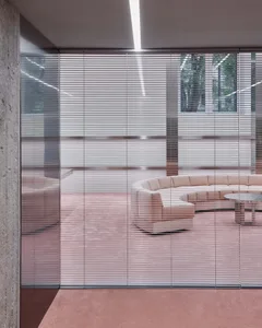 Modern minimalist retail space featuring glass walls, concrete flooring, and metal accents.