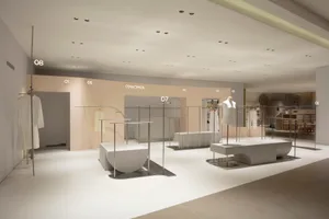 A minimalist retail store featuring white interiors with metal and concrete accents.