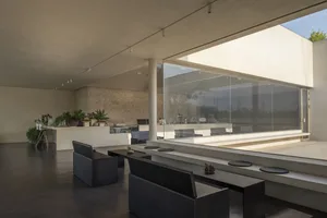 A modern coffee shop interior with concrete walls and floor, featuring a minimalist design and natural light.