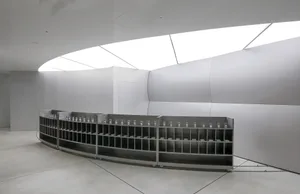 極簡展覽空間，展示現代金屬與玻璃裝置及雕塑作品。