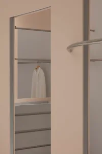 Modern minimalist closet with metallic clothing rack and white shirt hanging on hanger.