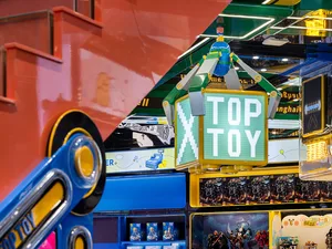 A colorful toy shop with various toys on display, including action figures, and a prominently displayed 'TOPTOY' sign.