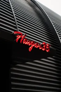 Modern storefront with metallic facade and a red neon sign reading 'Hanger35'.