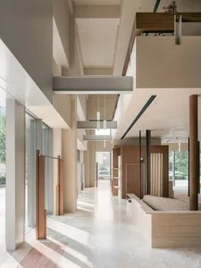 A modern residential interior with a minimalist design featuring concrete, wood, and glass materials.