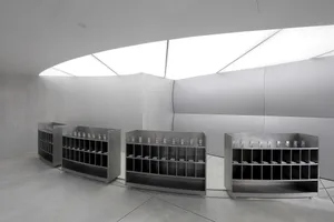 A minimalist exhibit space featuring metal shelves.
