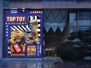 A brightly lit toy store storefront with a large robot cat display in the window.