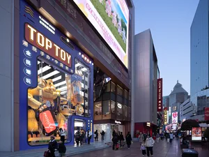 充滿活力的零售店面，藍色招牌上寫著「TOPTOY」，櫥窗內展示各種玩具。