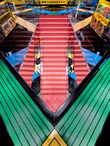 Industrial retail space showcasing a vibrant red staircase between yellow and green railings.