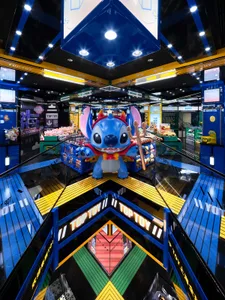 色彩繽紛的玩具店，地板為鏡面反光，店中央擺放大型史迪奇絨毛玩偶。