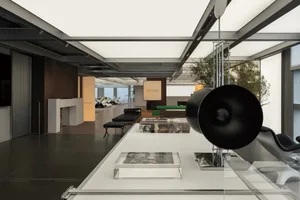 An industrial-style office interior with concrete floors, glass walls, metal elements, and a plant.