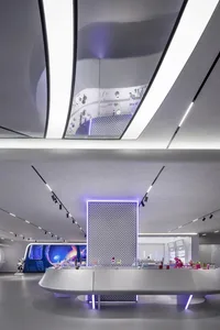 Modern minimalist retail store with glass walls and white concrete interior.