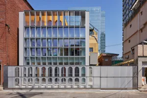 A modern office building with large glass windows and a sleek design.