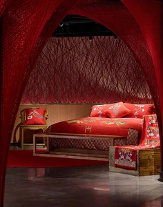 Modern bedroom designed with red fabric, wooden furniture, and geometric patterns.