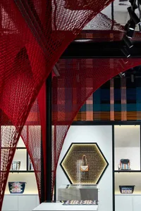 Interior design featuring a modern retail storefront display with textile-based materials and a geometric hanging sculpture.
