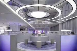 A modern retail store interior with glass displays, metallic accents, and fabric curtains.
