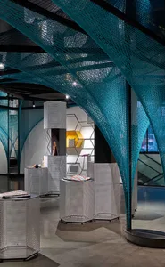 A modern retail space featuring metallic perforated panels and hexagonal structures.
