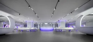 A modern minimalist retail space featuring sleek white surfaces and purple lighting.