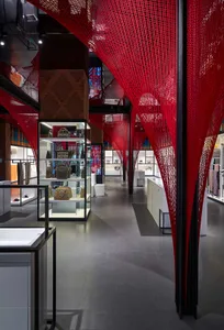 Modern retail space featuring red string lights hanging from the ceiling and black columns.