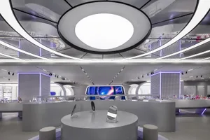 A modern retail store interior featuring metallic sheets and circular lighting fixtures.
