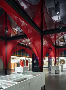 A retail space featuring red tension fabric structures and white display cases.