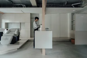 Minimalist living room with concrete floor, white walls, and furniture.
