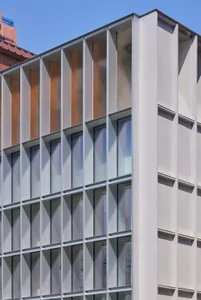 A modern building with a concrete façade and large windows.