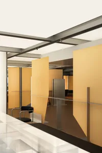 Modern office space featuring yellow paneled walls and a glass balustrade.
