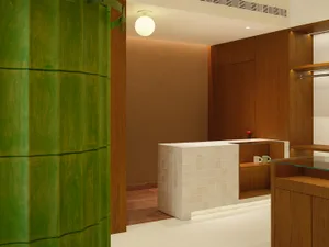 A modern reception desk made of white-tiled materials and wooden finishes.