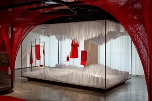 Minimalist fashion retail display featuring white structures and red textiles.