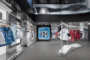 A modern retail store interior featuring sleek metal, glass, and white furniture.