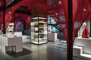 A modern retail space featuring bold red geometric netting architecture.