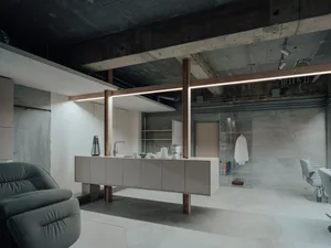 Modern, minimalist living, dining, and kitchen area with concrete walls and floor.