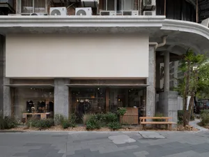 Concrete storefront with glass windows and a simple, minimalist design.
