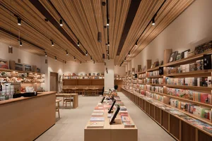 A cozy bookstore with wooden shelves filled with books and a counter area.
