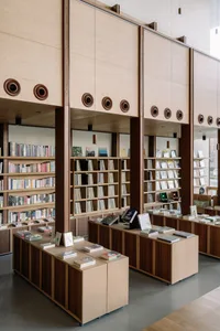 一間以木質元素打造的現代書店，內有書架與桌椅