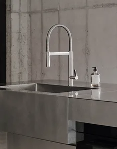 Concrete kitchen countertop with minimalist faucet and hand soap dispenser.