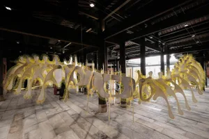 A modern artistic installation featuring metallic yellow elements.