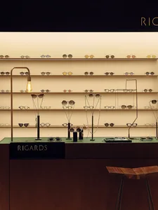 Display of sunglasses in a modern interior optical shop with wooden and steel elements