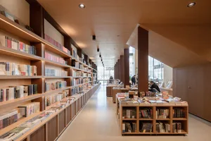 Minimalist modern library interior featuring walnut and glass shelves.
