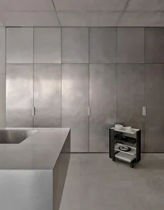 A streamlined, modern kitchen with metallic cabinetry and a large countertop.