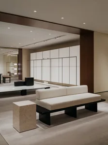 Minimalist lobby interior featuring concrete flooring and furniture.
