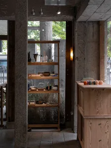 A modern retail display featuring wooden shelves, concrete columns, and glass objects.