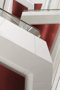 Modern commercial staircase featuring metallic, glass, and concrete materials.