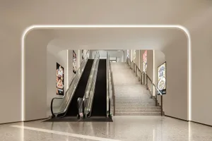 Modern interior design featuring sleek escalators and stairs constructed from concrete and glass.