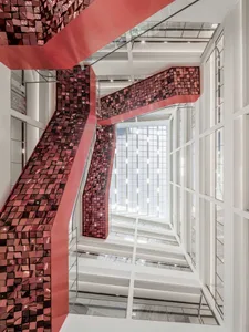 Modern glass staircases adorned with red tiles in an interior design setting.