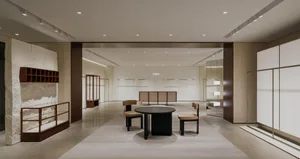 A minimalist modern lobby interior with a concrete floor, stone walls, and a contemporary table and chairs.