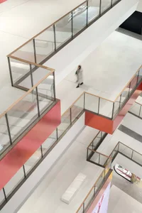 A modern shopping center interior featuring red accents on a white and gray floor.