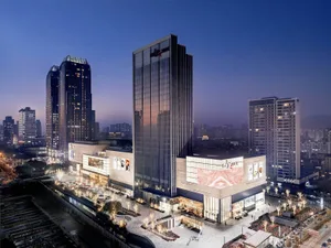A modern shopping mall with glass and concrete structures at dusk.