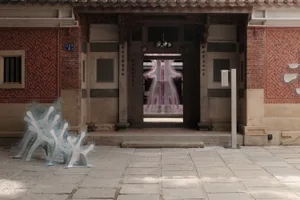 A traditional building with a tile and concrete exterior featuring intricate carvings and decorative elements.